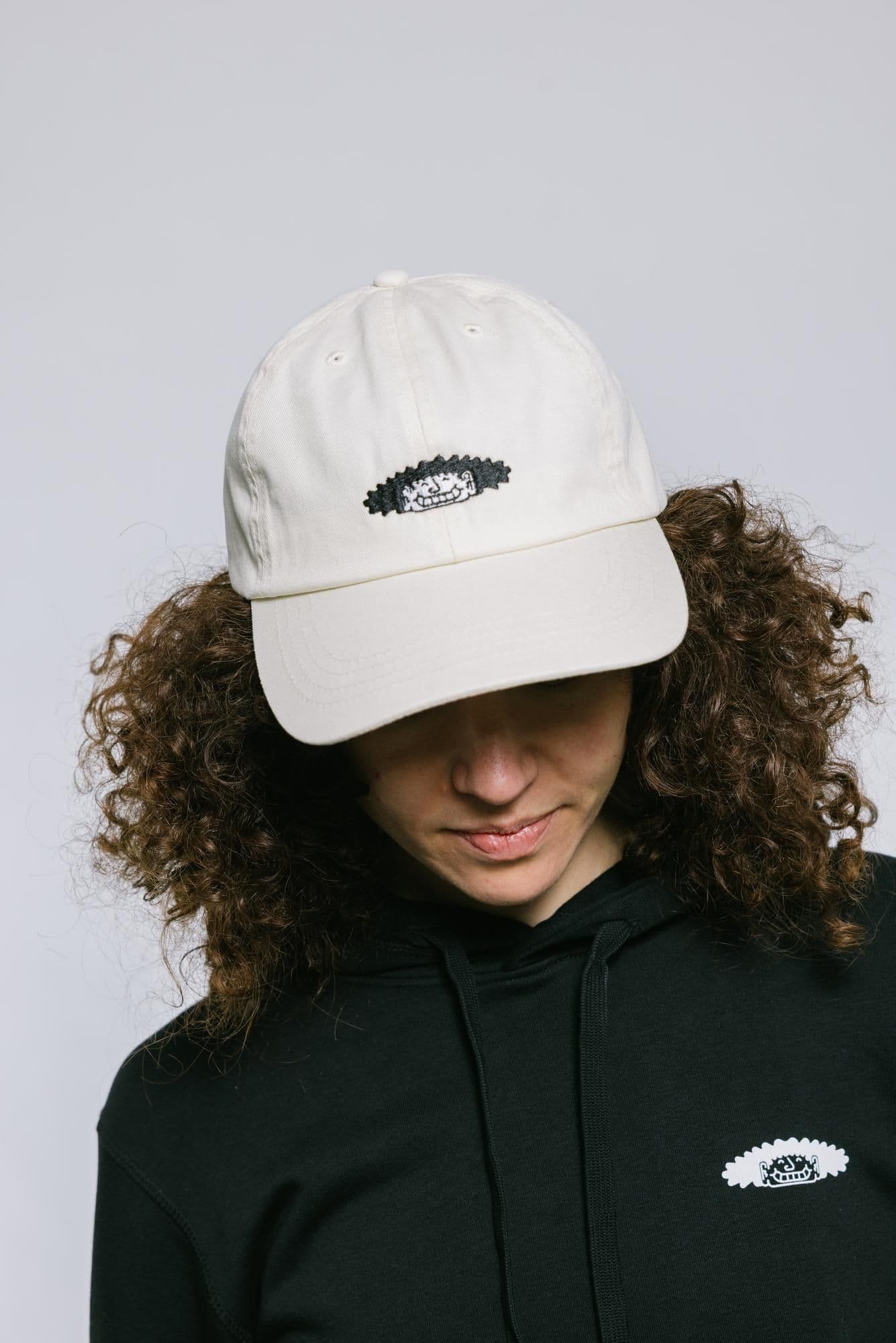 Eine Person trägt die WDC-Kappe und den WDC-Hoodie.