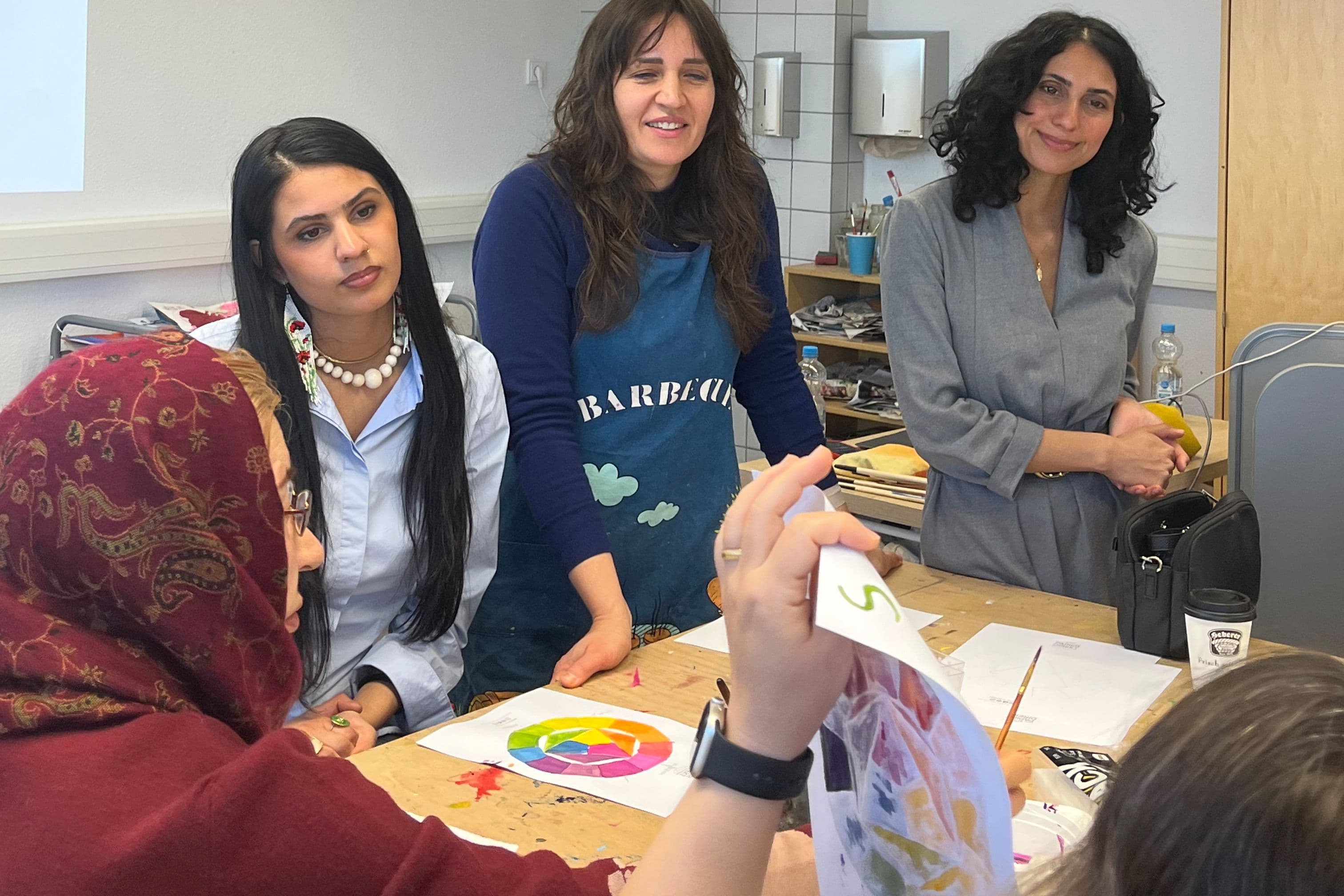 Frauen arbeiten gemeinsam an bunten Entwürfen an einem Tisch