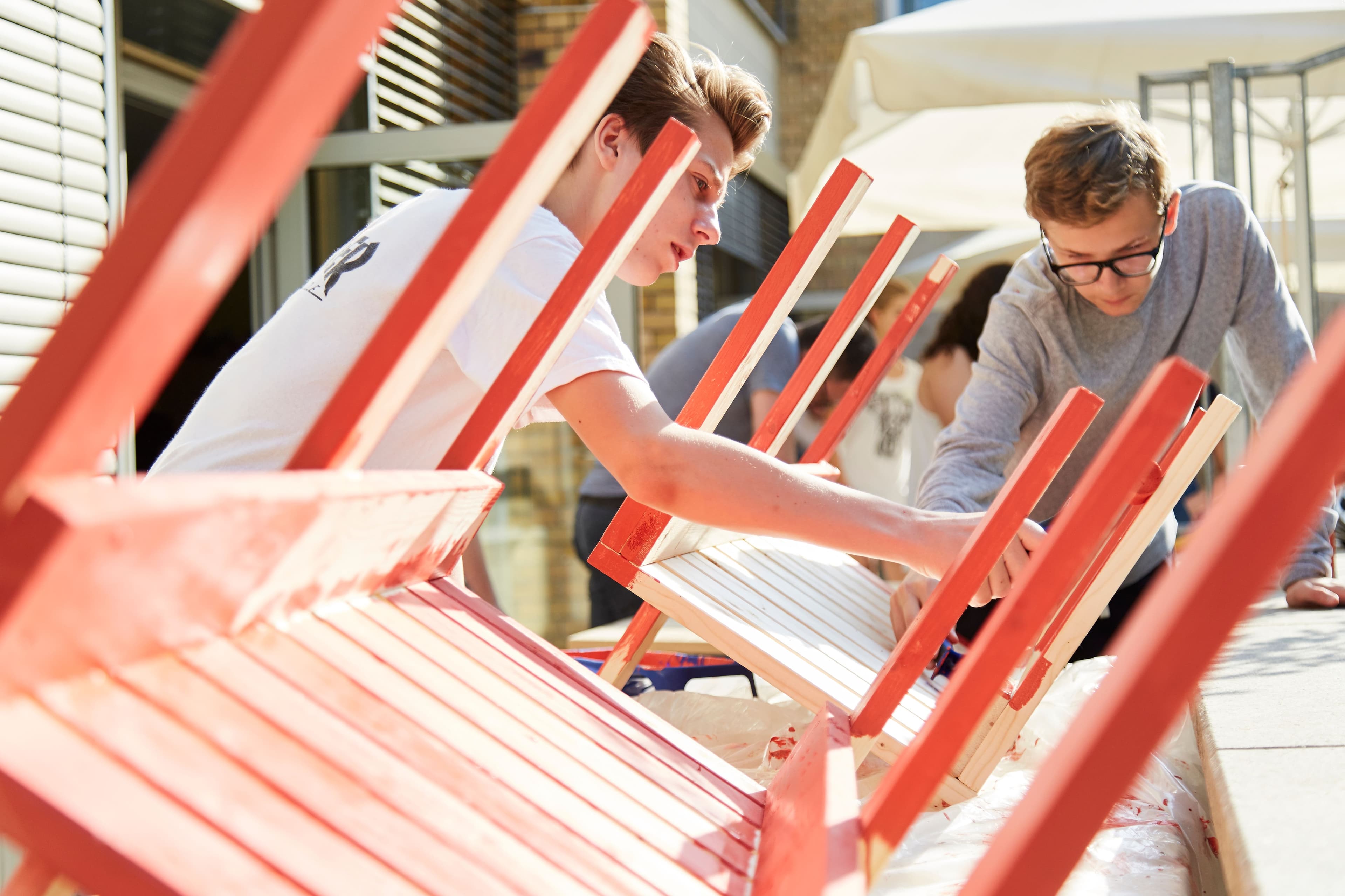 Junge Menschen basteln an Holzmöbeln