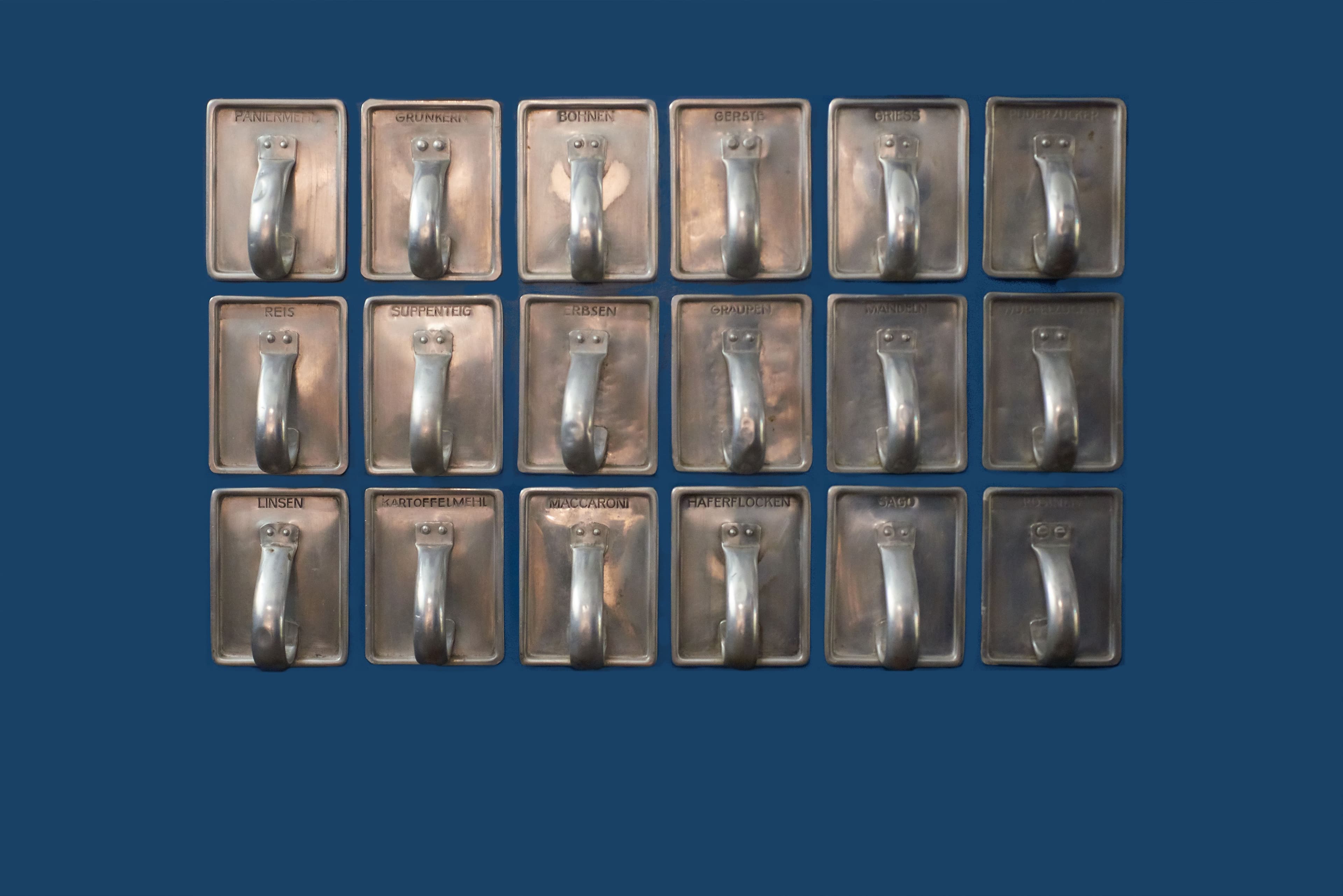 Auf blauem Hintergrund sind verschiedene Metallfächer mit unterschiedlichen Lebensmittelkennzeichnungen zu sehen.