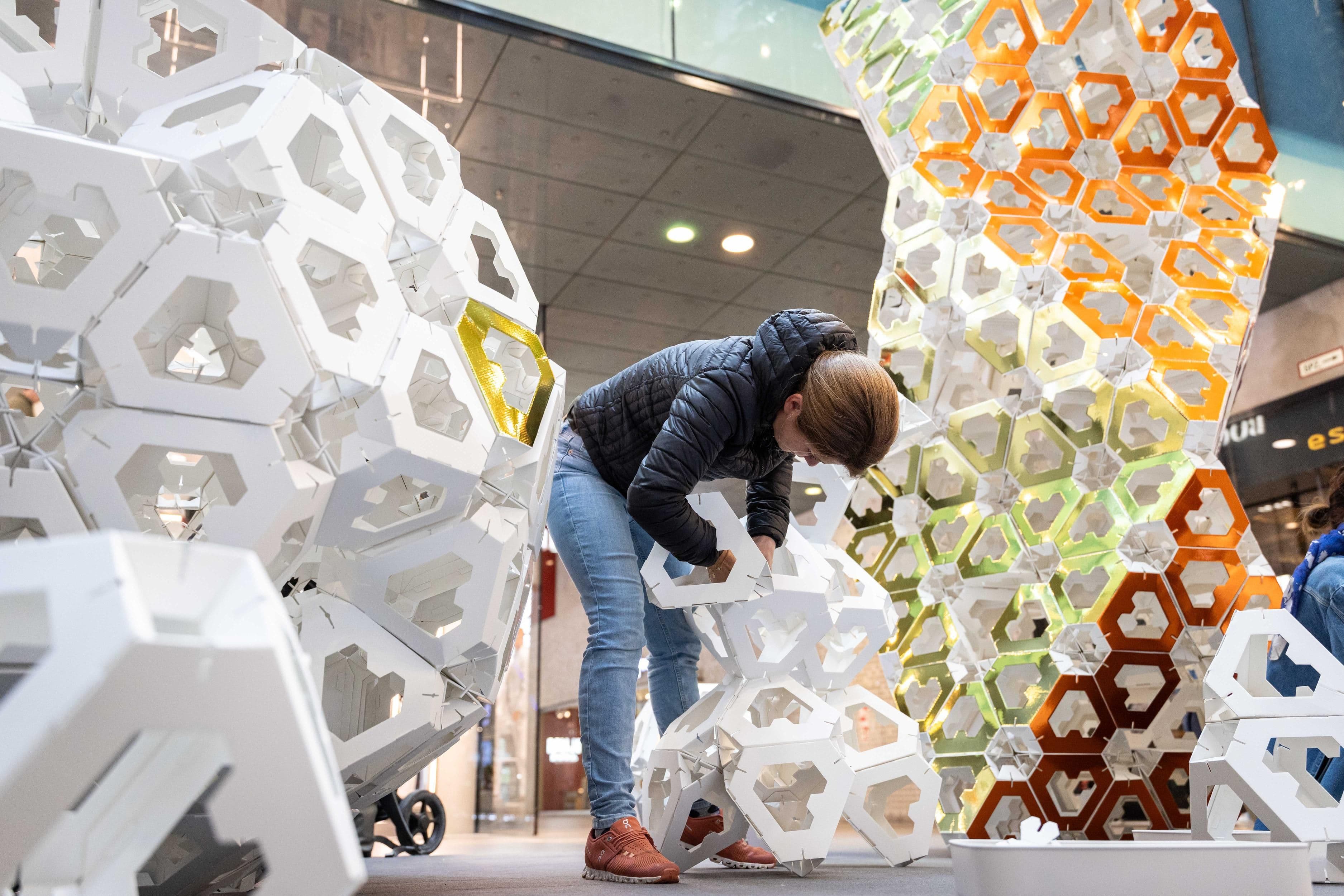 Eine Frau bastelt an einer Papierskulptur der Collective Paper Aesthetics