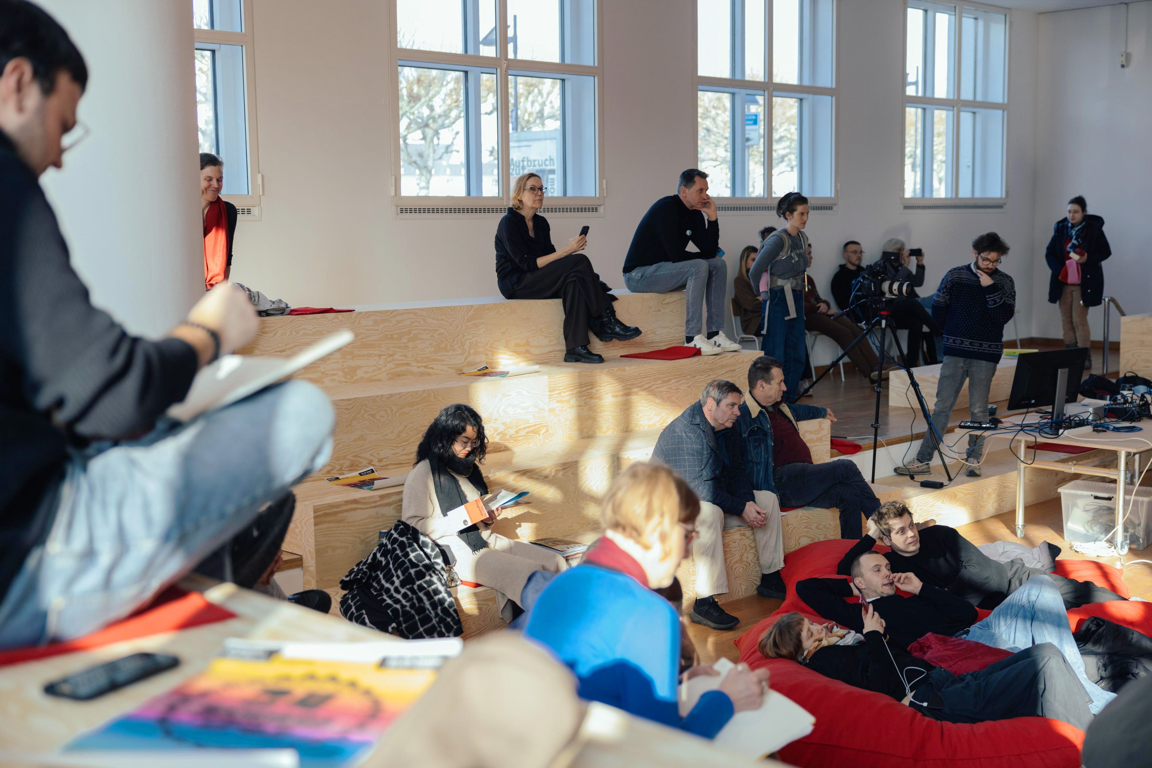 Menschen sitzen auf den Emporen im WDC Hub