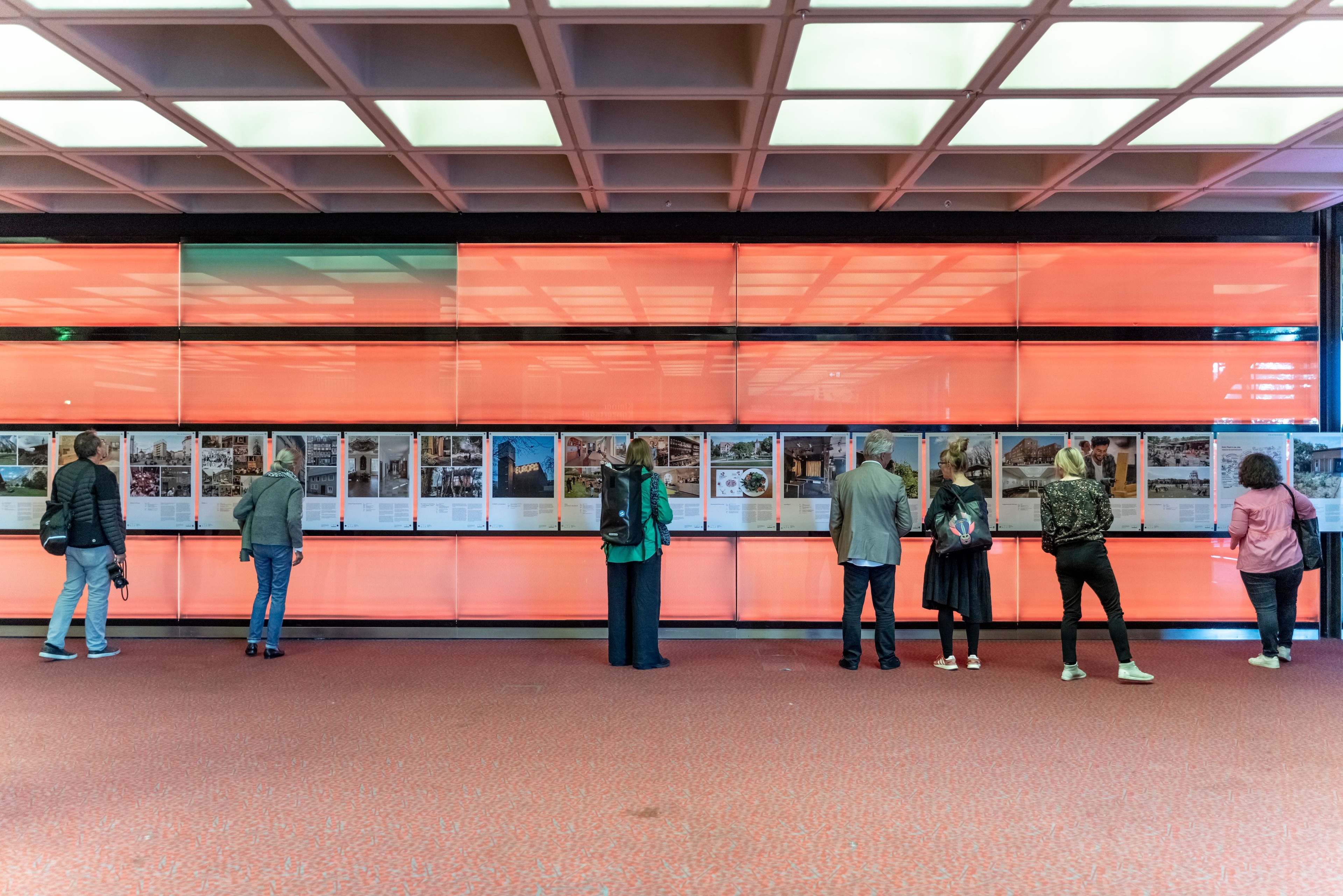 Menschen stehen vor Exponaten in einer Ausstellung