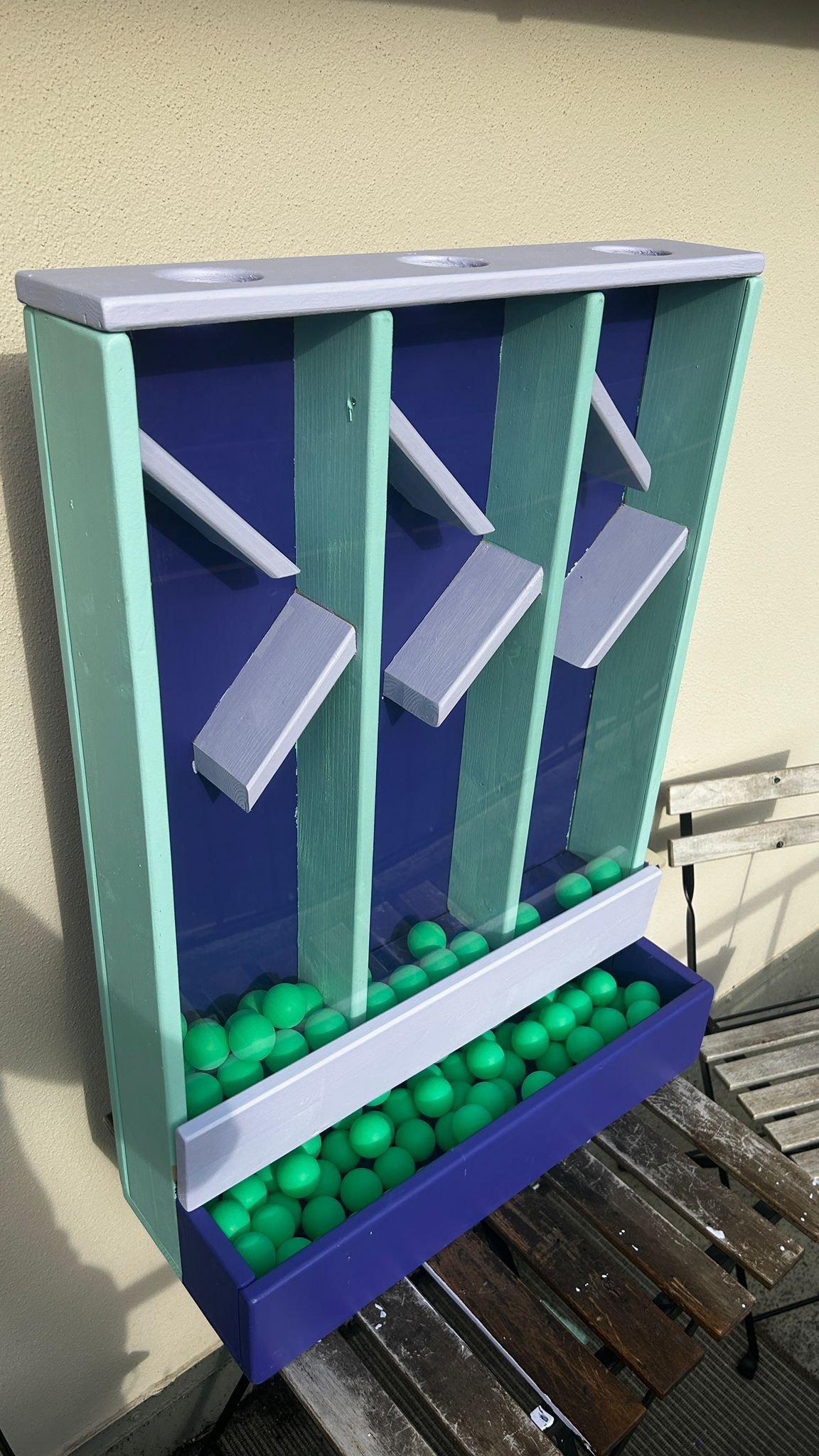 Ein Abstimmungs-Holzkasten ist mit Bällen gefüllt.