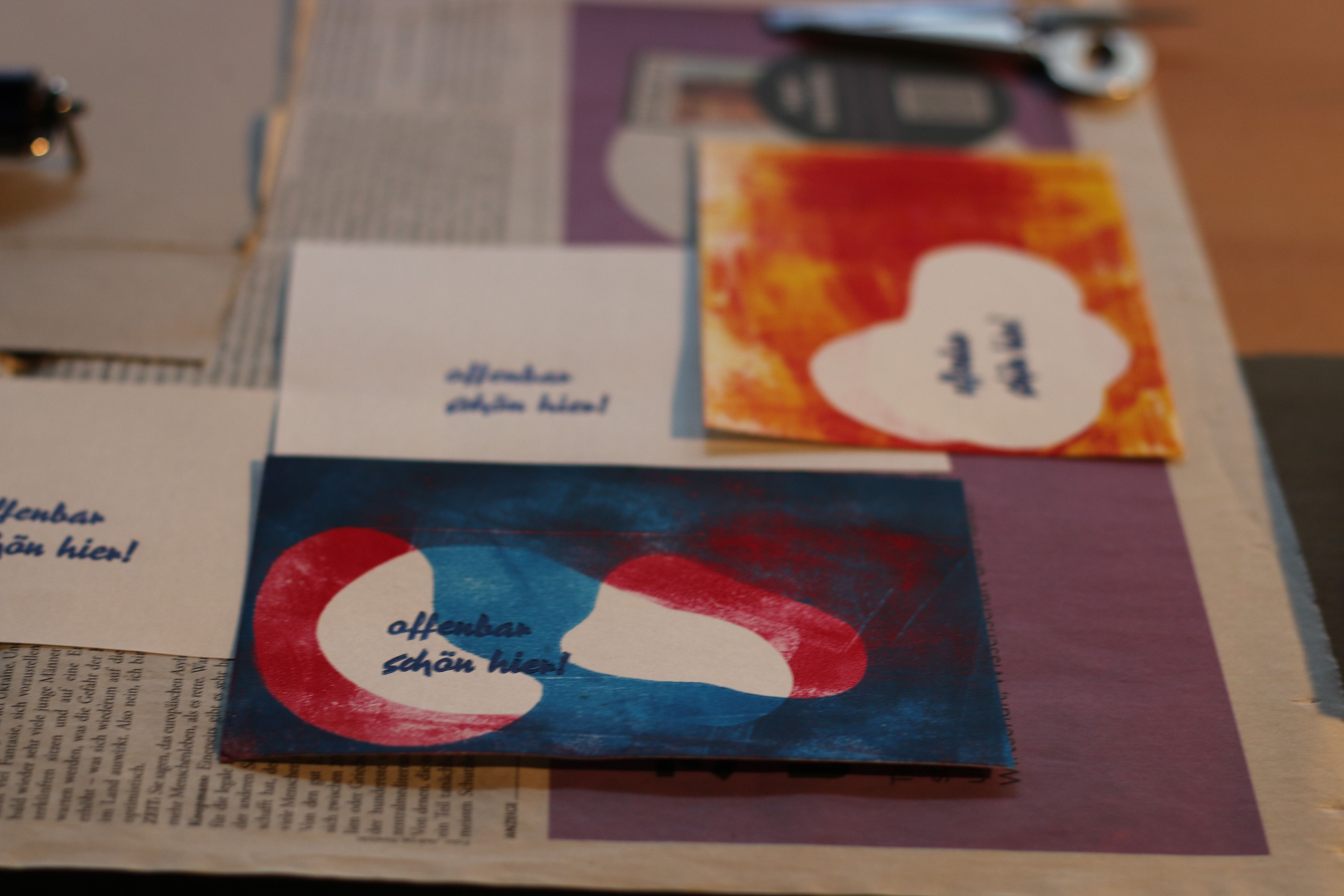 Auf einem Tisch liegen bedruckte Postkarten.