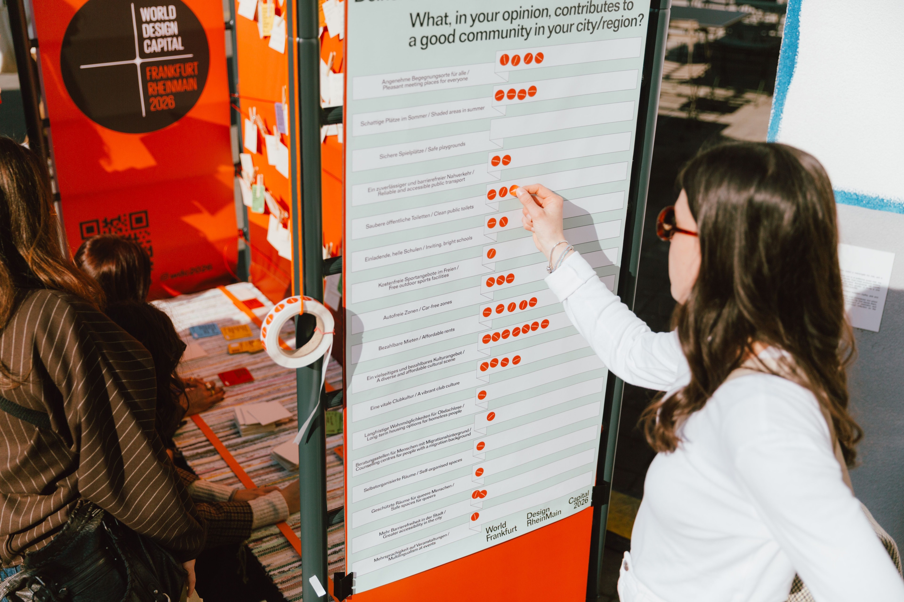 Foto einer Person, die einen Sticker auf ein Plakat klebt