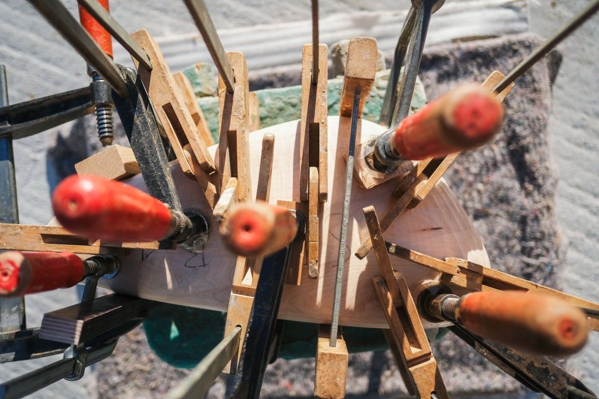 Foto verschiedener Schraubzwingen an einem Stück Holz