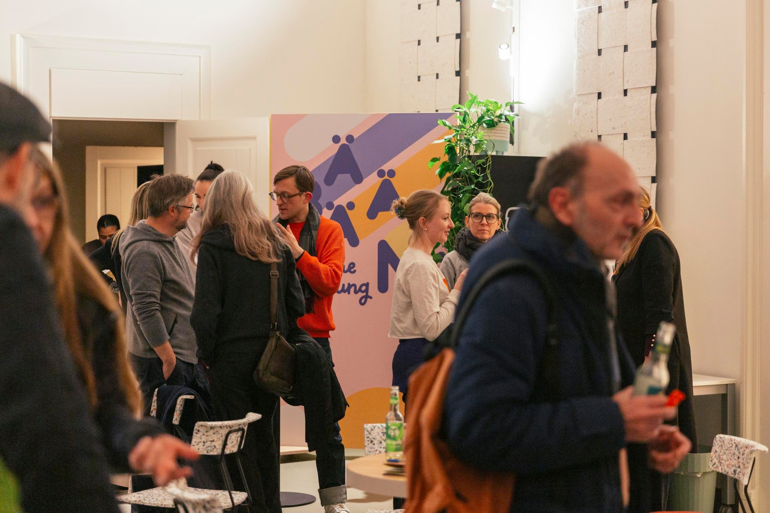 Menschen unterhalten sich angeregt in den Räumlichkeiten des Wiesbadener Heimathafen