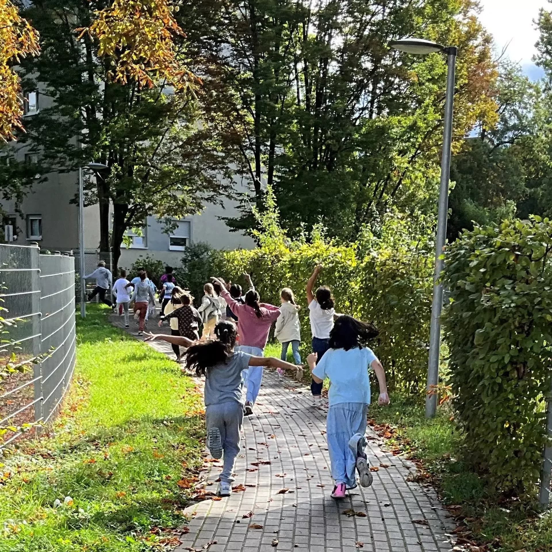 Kinder rennen auf einem Gehweg