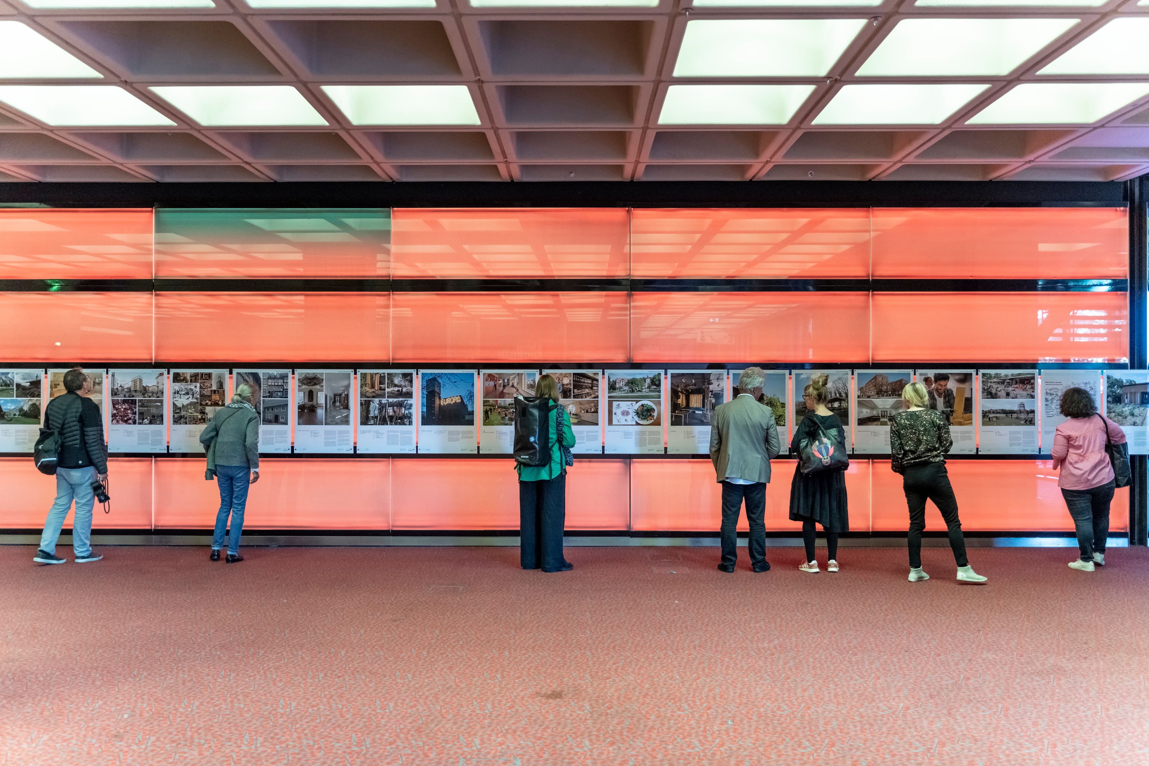 Menschen stehen vor Exponaten in einer Ausstellung