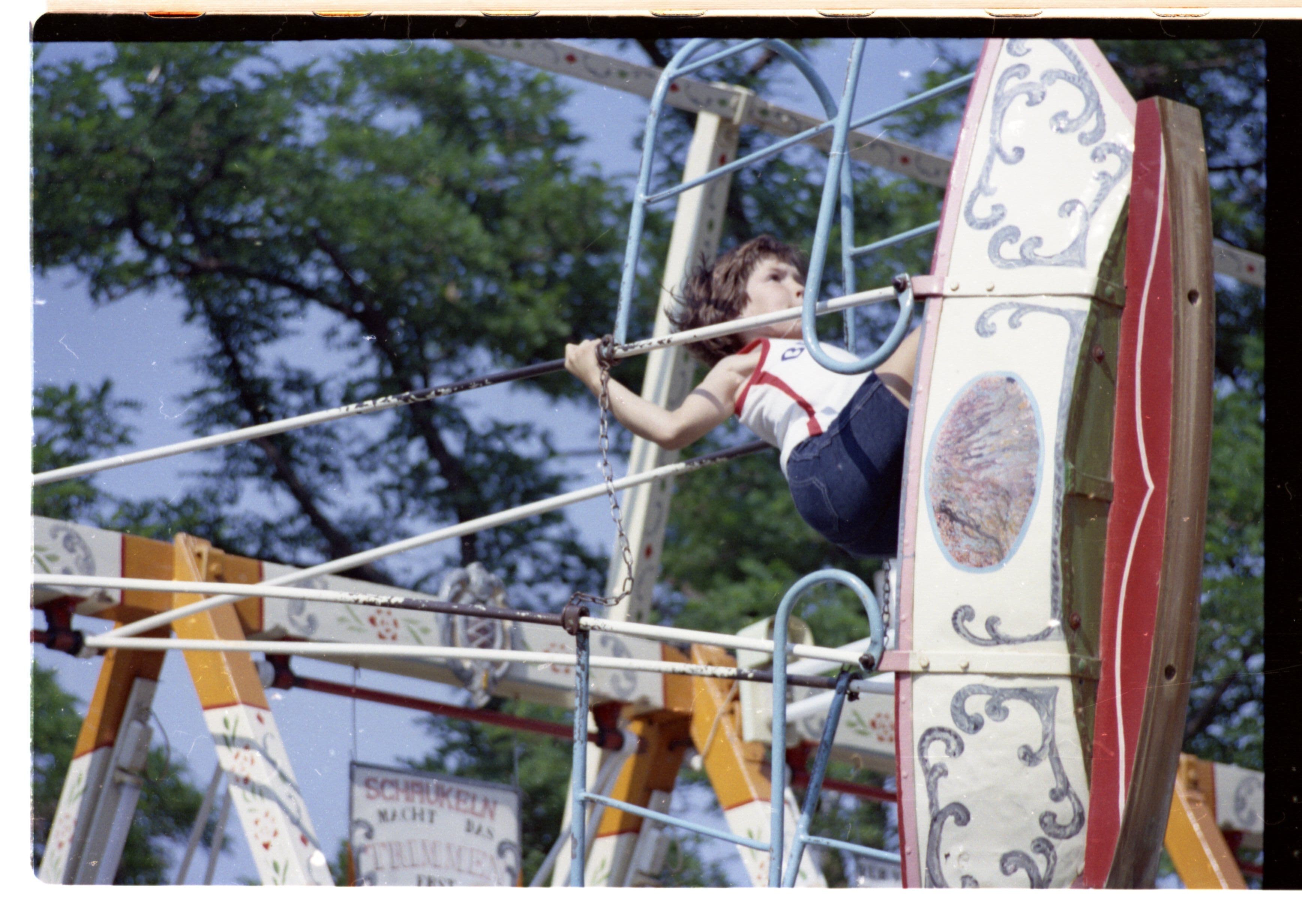 Eine historische Aufnahme eines Jungen in einer Schiffschaukel
